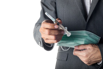 Man in suit holding syringe and face mask
