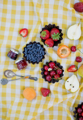 Picnic at the park. Fresh fruits and small jars with jam