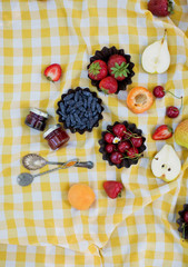 Picnic at the park. Fresh fruits and small jars with jam