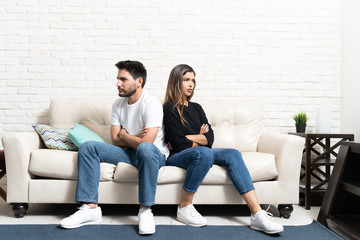 Fototapeta premium Unhappy Couple Sitting On Sofa At Home