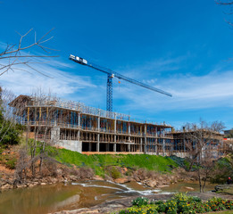 A concrete frame of a building being constructed in Greenville, South Carolina with a crane