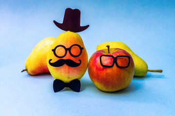 Funny apple and pear in glasses and a hat.