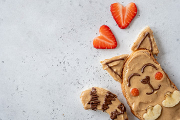 Funny cute cat sandwich with peanut butter, banana and strawberry for kids