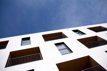 Exterior of new apartment buildings on a blue cloudy sky background. No people. Real estate business concept.