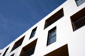 Exterior of new apartment buildings on a blue cloudy sky background. No people. Real estate business concept.