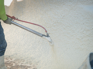 Man spraying cement during a swimming pool renovation.