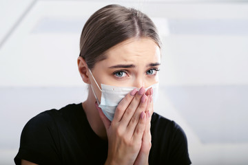 A girl sick with a new coronavirus coughs in a disposable facial mask. Epidemic corona virus. Covid-19 protection. Quarantine all over the world. White background