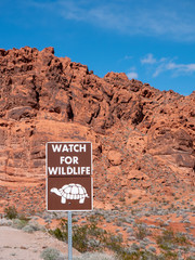 Watch for wildlife (desert tortoise) sign with a background of red rock.