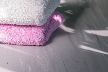 bath towels stack, natural light and shadows, selective focus. hygiene and self care concept