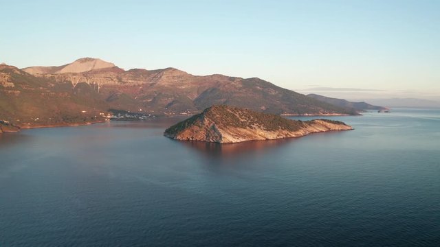 Drone flight around the mountain slopes and rocky coastline of Thasos island and the little island Nisida Kinira, Greece