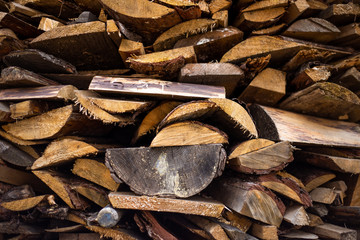 chopped dry firewood cooked for the fireplace and stove lying in a heap one on one on the street. Ready to Burn in Fireplace