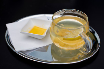 A cup of jasmine tea with lemon and honey