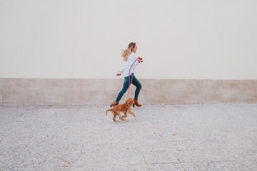 young woman at the street walking with her cute cocker dog. Lifestyle outdoors with pets