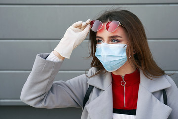Young woman with beautiful blue eyes wearing protection face mask against coronavirus MERS-Cov,...