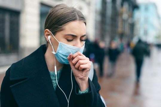 Prevention of coronavirus outbreak in 2020. Portrait of young european woman wearing a mask in the city street. Prevent pollution and disease concept.