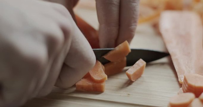 Cutting a carrot on a chopping board.