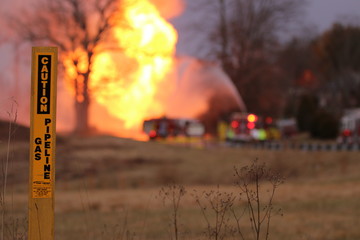  A gas line marker ominously indicates the source  of the distant fire
