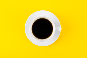 Black coffee in a cup on a yellow background
