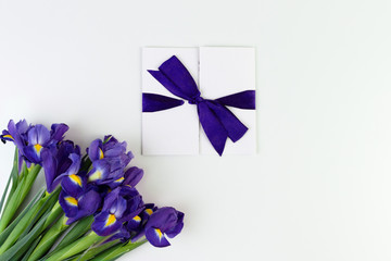 Gift card and Lovely iris flowers isolated on white backdrop, holiday postcard with copy space. Gift mockup.