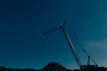 construction site with cranes on blue sky background