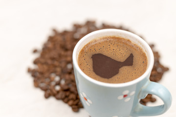 Cup Of Black Coffee With Coffee Beans On The White Table