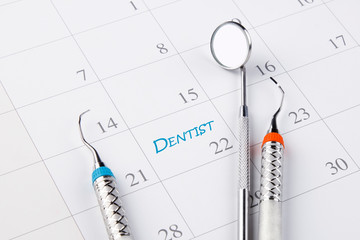 Dentist appointment in calendar with dental instruments. Dental hygienist checkup conceptual image.