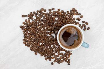 Cup Of Black Coffee With Coffee Beans On The White Table