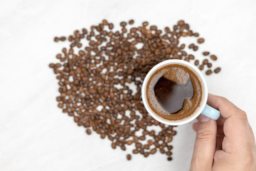 Cup Of Black Coffee With Coffee Beans On The White Table