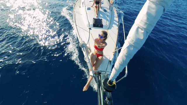 Half-round view of two women being happy while riding a yacht