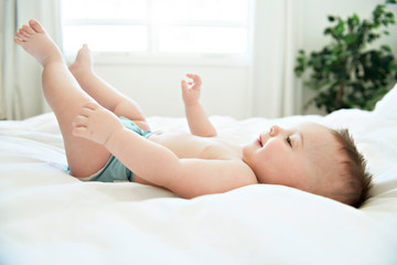 Obraz na płótnie Canvas cute baby boy lying on a white bed