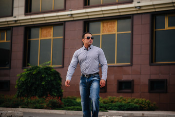 Young successful man near an office building. Business