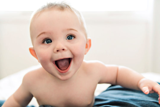 surprise and happy baby in bed at home