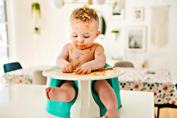 Little baby boy eating her dinner and making a mess