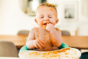 Little baby boy eating her dinner and making a mess