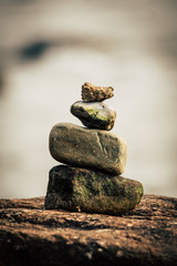 four stones piled on top of each other to form a stone tower for Zen and meditation exercises