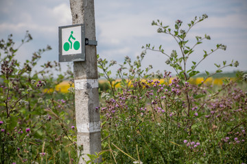 cycle route sign on a pillar near the field