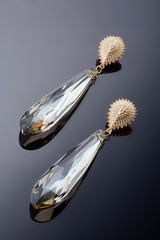 Plastic jewelry earrings with crystals and stones for women on a dark background.