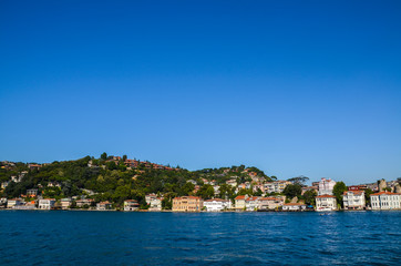 Fototapeta na wymiar Beautiful view of the residential area, hillside waterfront colorful houses and a park from the Bosphorus Strait in Istanbul, Turkey.