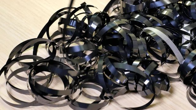 Tape pulling up a jumbled cassette reel. Tangled wiggle wavy audio tape in random fashion. Close up, Time lapse. 