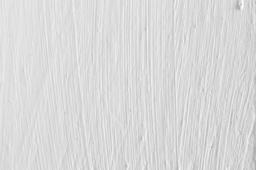 Texture of white paint with stains from a brush on the wall, background