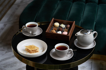 Obraz na płótnie Canvas Afternoon tea with cake on restaurant table, close-up.