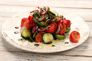 Spring-summer salad of tomatoes, cucumbers, red onions, with dill, cilantro and blue basil, seasoned with olive oil and evaporated balsamic vinegar.