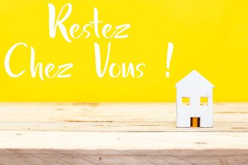 white wooden house  with french word restez chez vous translated in english stay at home 