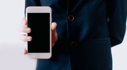 Hands holding blank screen smartphone. Female hands and texting mobile phone. Office.