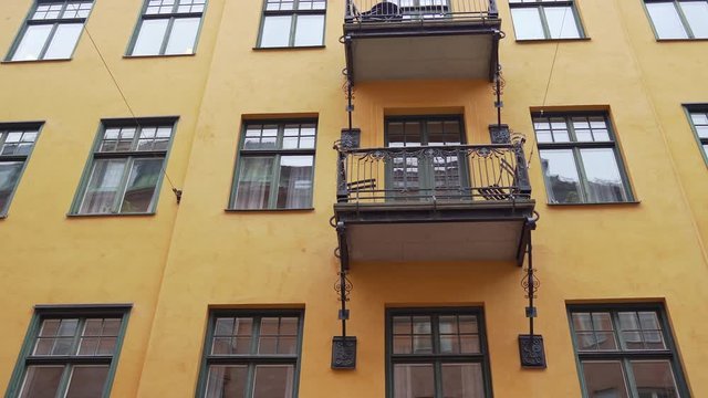 Apartment buildings on european streets in old city. Scandinavian windows. Facades of colorful houses in narrow streets of Stockholm, Sweden. Traveling concept. Steadicam shot