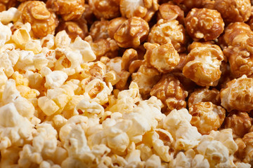 Flatlay of salted popcorn with cheese. Heap of homemade delicious popcorn on a rustic wooden table. Snacks and food for a movie theater or cinema. Fastfood background.  Strip texture