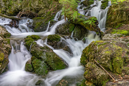 Ein Bach bahnt sich seinen Weg zwischen Felsen hindurch