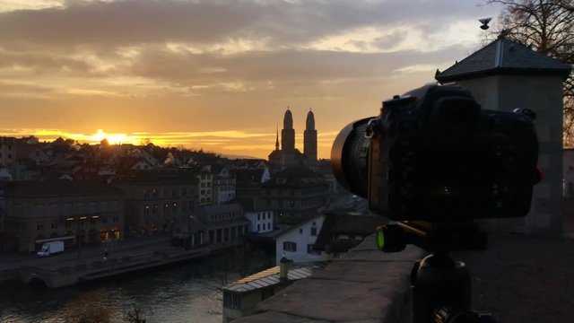 DSLR camera on tripod taking timelapse pictures of sunset / sunrise over the city