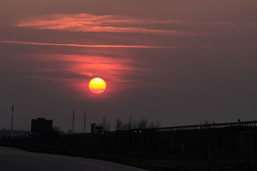 Sunset near the road. The big red sun at sunset. Background.
