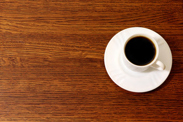 A cup of coffee on a wooden table, background. Copy space.